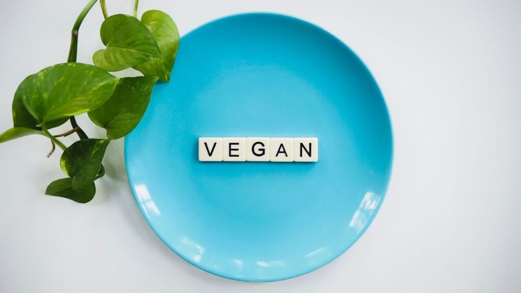 Letter tiles spelling 'vegan' on a blue plate
